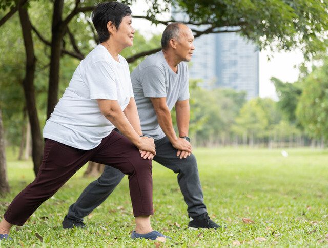 Asian Senior man and woman doing exercise at park outdoor in the morning.